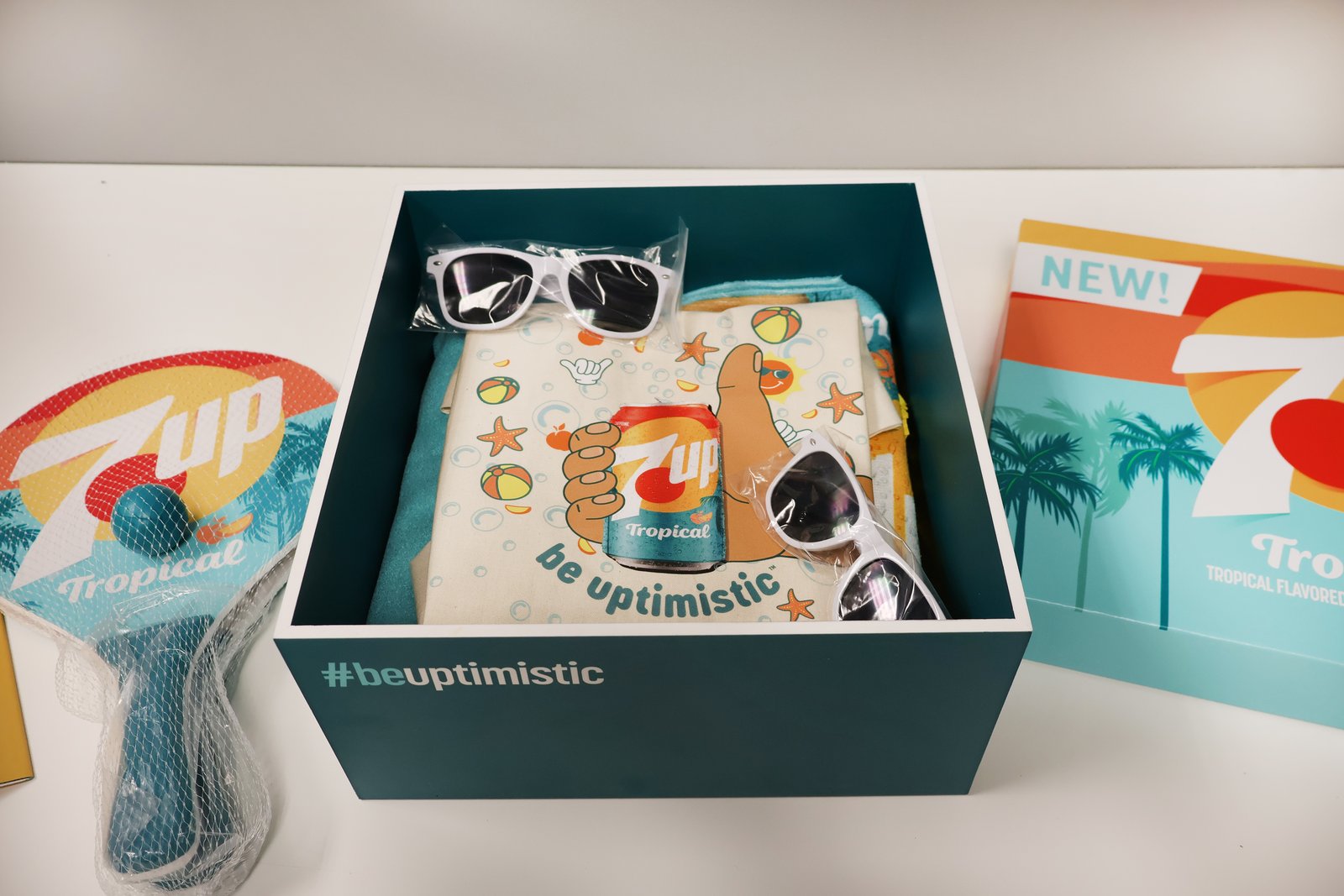 Open 7UP Tropical kit with sunglasses, fabric items, and branded paddle accessories