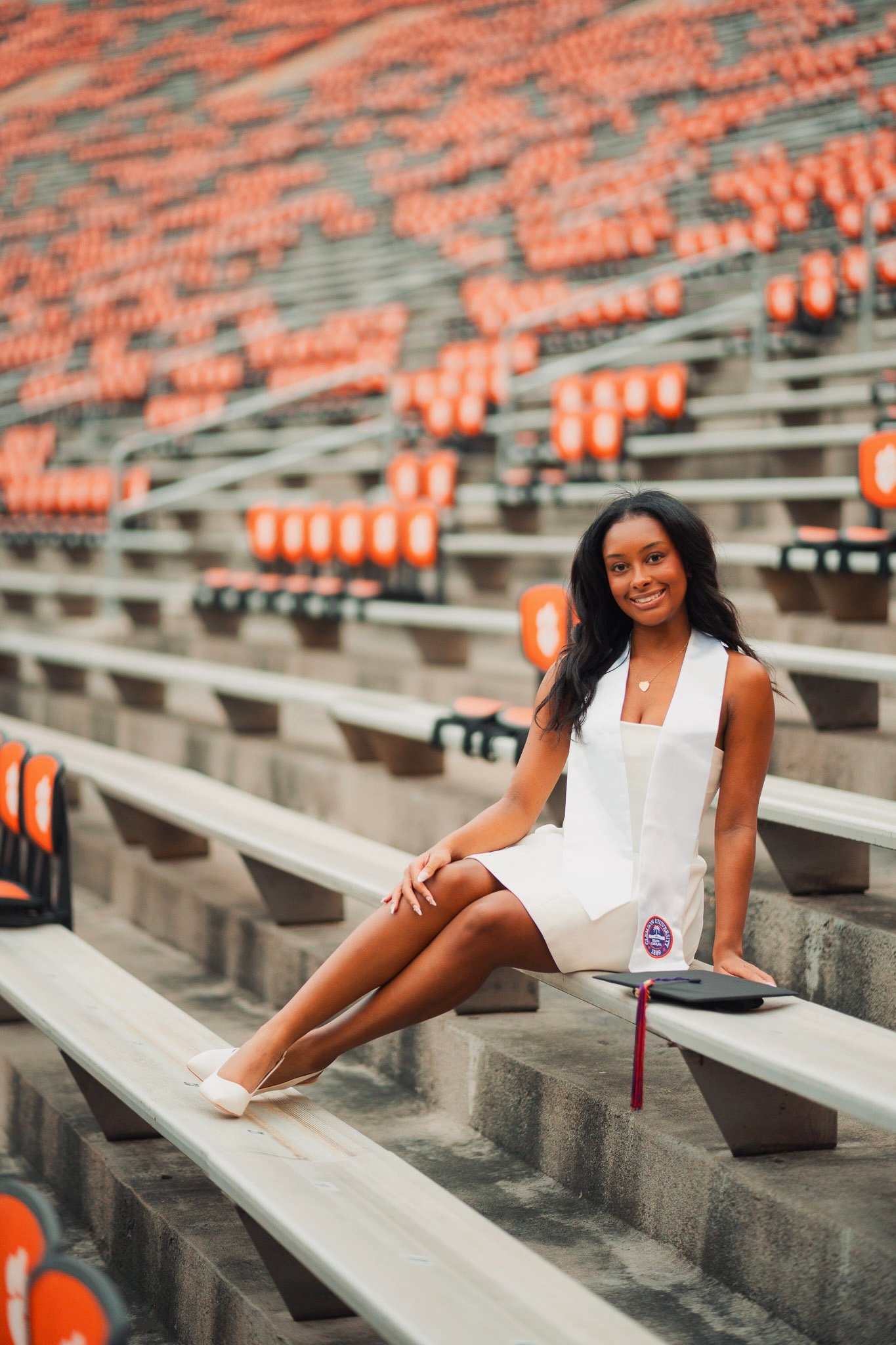 Madison seated in the Clemson stadium with her graduation cap