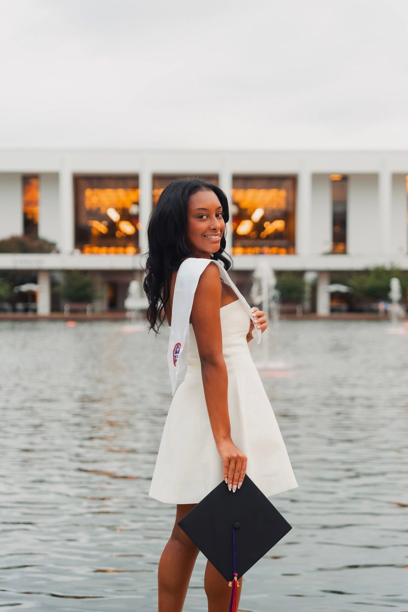Madison in her graduation dress beside the water
